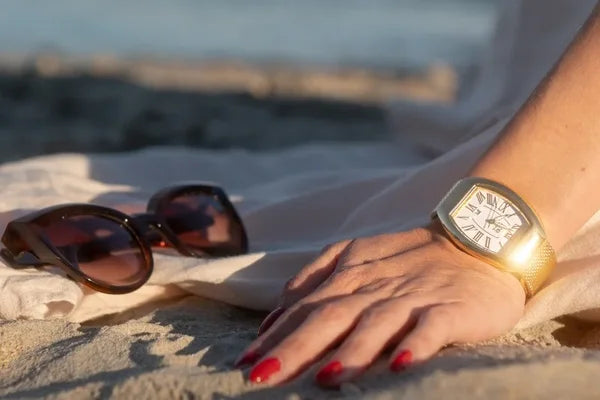 Frauenhand im Sand im Ice Watch