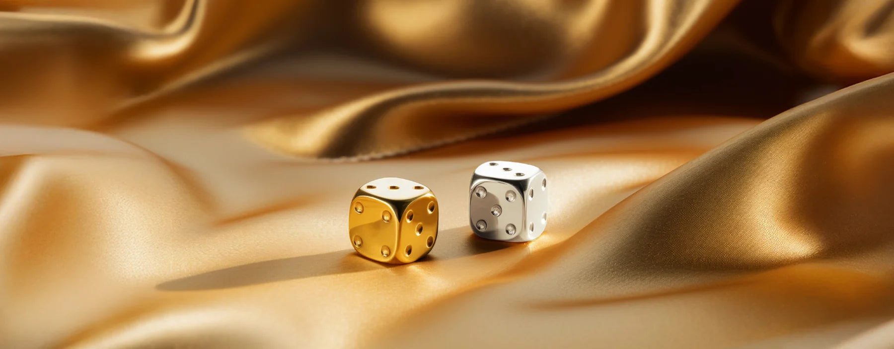 Würfel in Gold und Silber auf goldenen Stoff